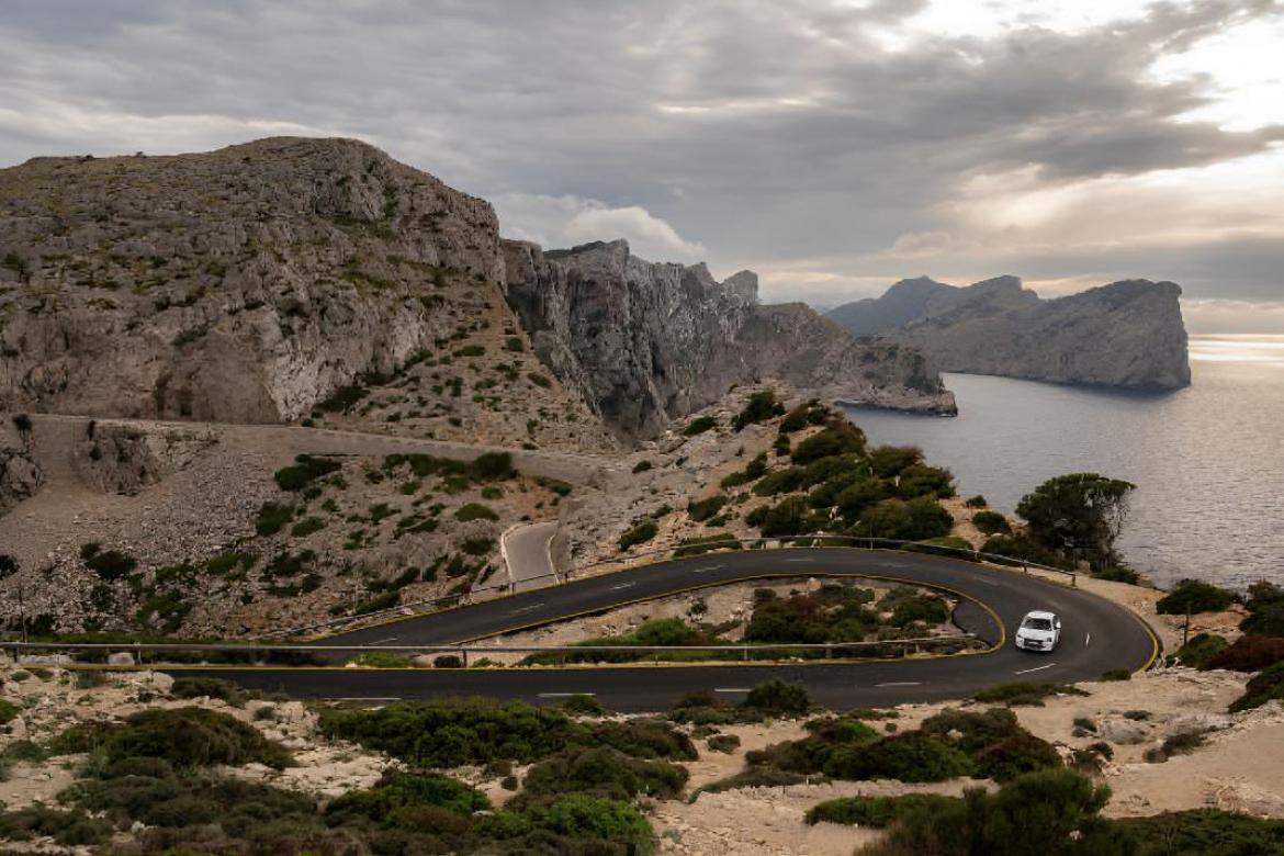Un coche circulando por una carretera sinuosa en el Cabo de Formentor, Sierra de Tramontana (Mallorca).