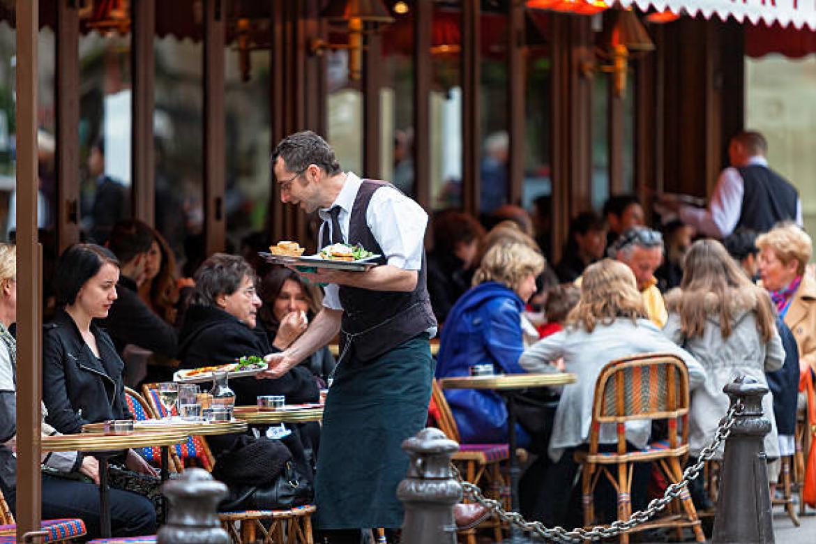 Paris, France - April 27, 2012: Waiter serving food in Cafe Le Bonaparte at Place Saint-Germain-des-Prés.