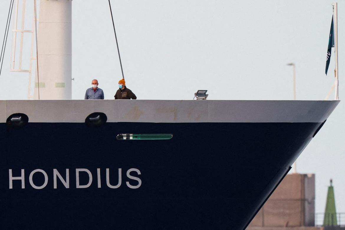 People wearing masks stand aboard the cruise ship MV Hondius at the port of Granadilla de Abona, after being affected by a hantavirus outbreak, in Tenerife, Spain, May 10, 2026. REUTERS/Hannah McKay      TPX IMAGES OF THE DAY