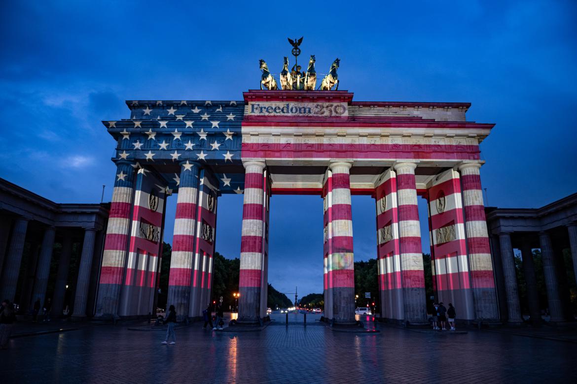 La gente contempla la Puerta de Brandeburgo, iluminada con los colores de los Estados Unidos de América para conmemorar el 250 aniversario de la independencia estadounidense.