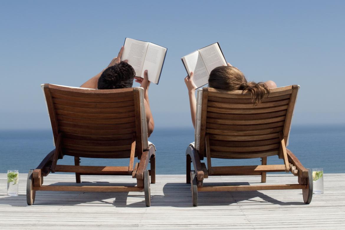 Una pareja leyendo libros durante sus vacaciones de verano