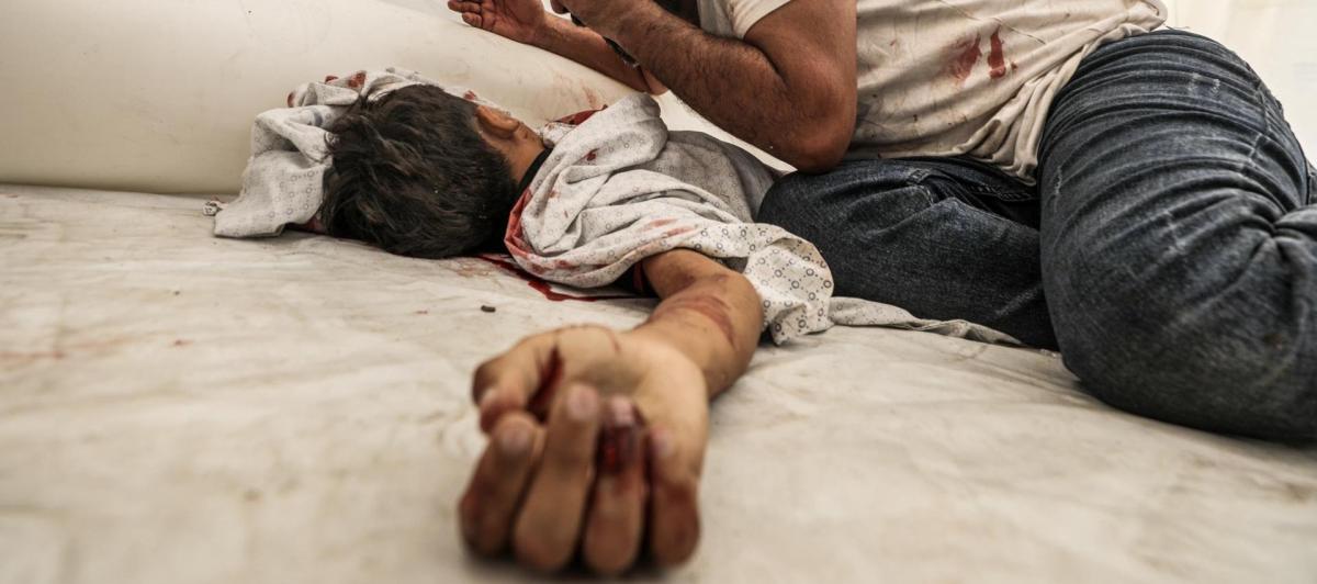 Un padre palestino llora sobre el cadáver su hijo fallecido en los bombardeos de Israel en represalia por el ataque de Hamás, en el hospital Al-Shifa.