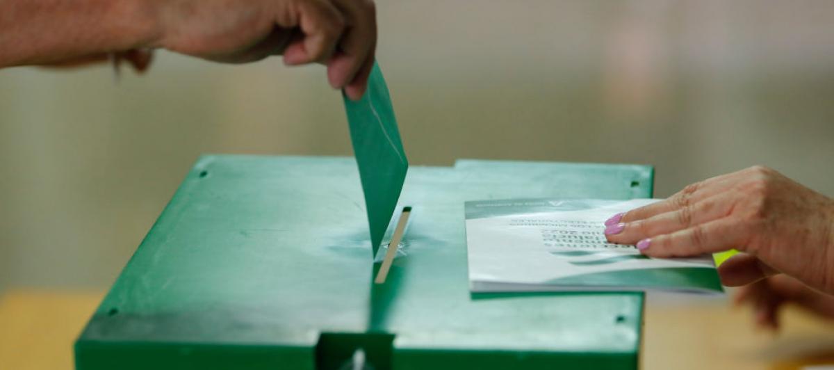 Una persona, a punto de depositar su papeleta