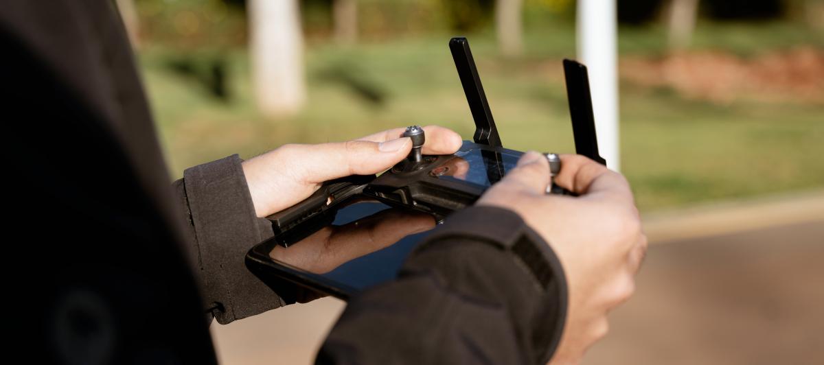 Una persona controlando un dron mediante un joystick.