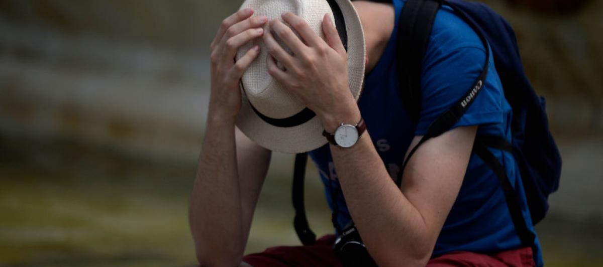Un hombre se protege como puede en un día de calor fuerte en Sevilla