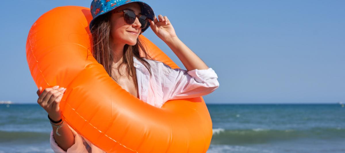 Una chica se coloca las gafas de sol junto al mar en una imagen de archivo.