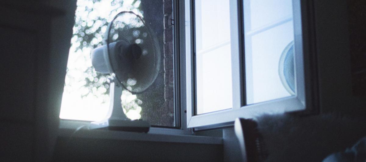 Un ventilador junto a una ventana en una imagen de archivo.