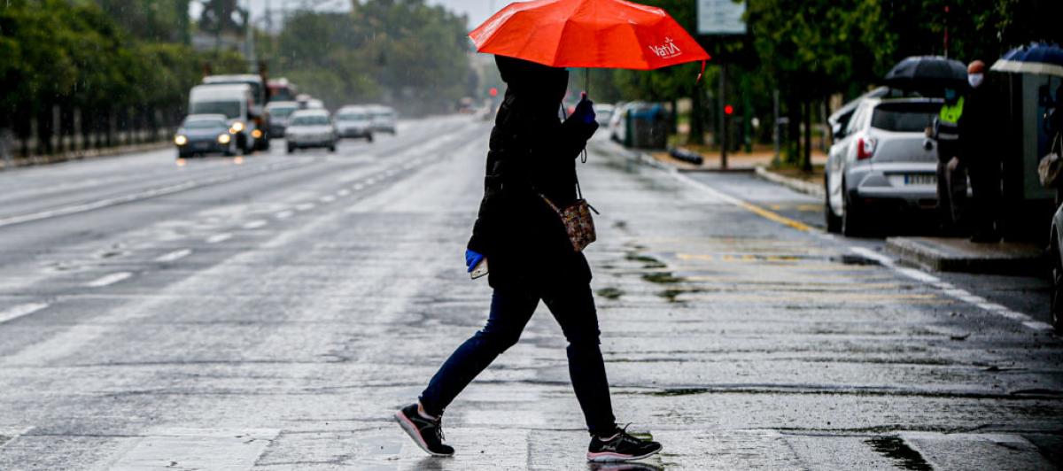 Una persona, bajo un paraguas en una lluviosa calle de Sevilla