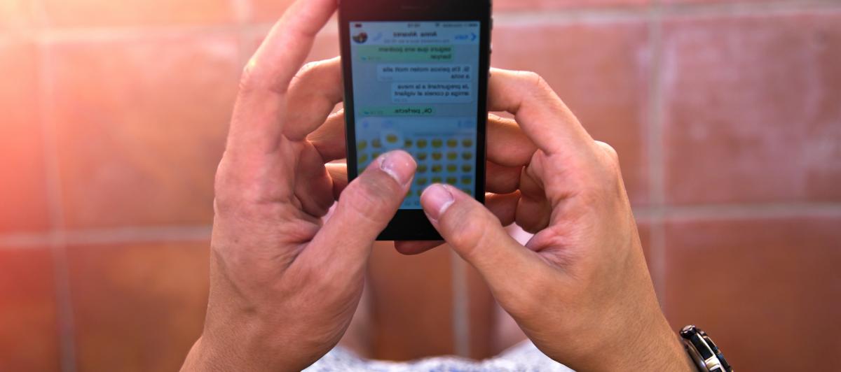 Imagen de archivo de una persona leyendo una conversación de WhatsApp.