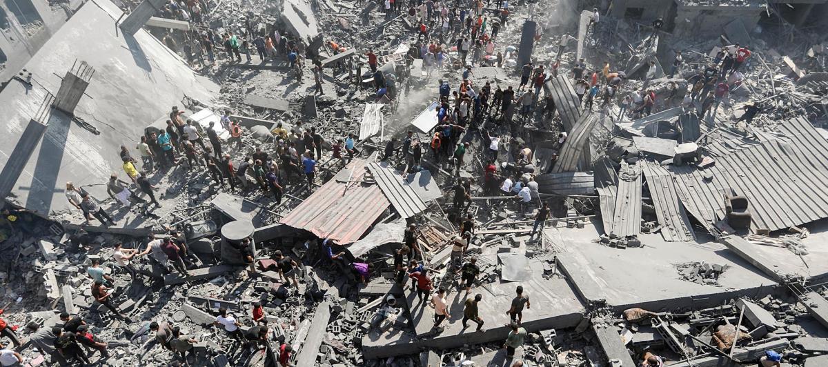 Palestinos buscan supervivientes entre los escombros de un edificio de viviendas alcanzado en un ataque israelí en el campo de refugiados de Khan Younis.