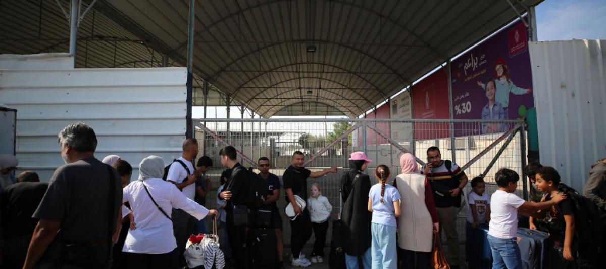 Un grupo de palestinos apostados en el paso de Rafah con la esperanza de cruzar a Egipto.
