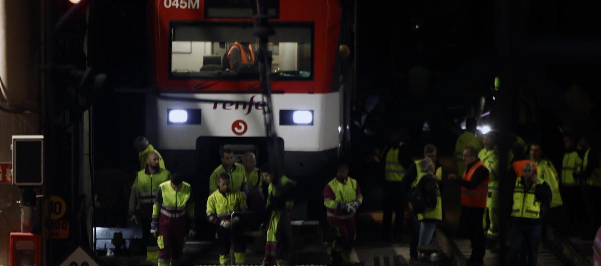 Varios operarios junto al tren de Cercanías que ha descarrilado este martes