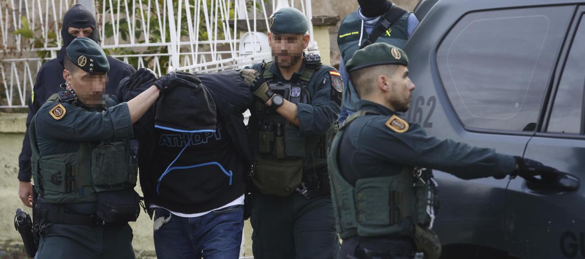Agentes de la Guardia Civil y de los Mossos d'Esquadra custodian a uno de los detenidos en Martorell (Barcelona).