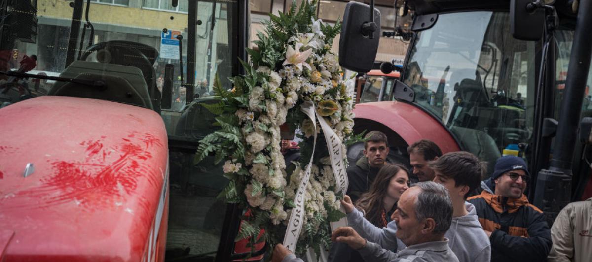 Un trabajador del campo coloca una corona fúnebre en su tractor durante unas protestas en Cataluña