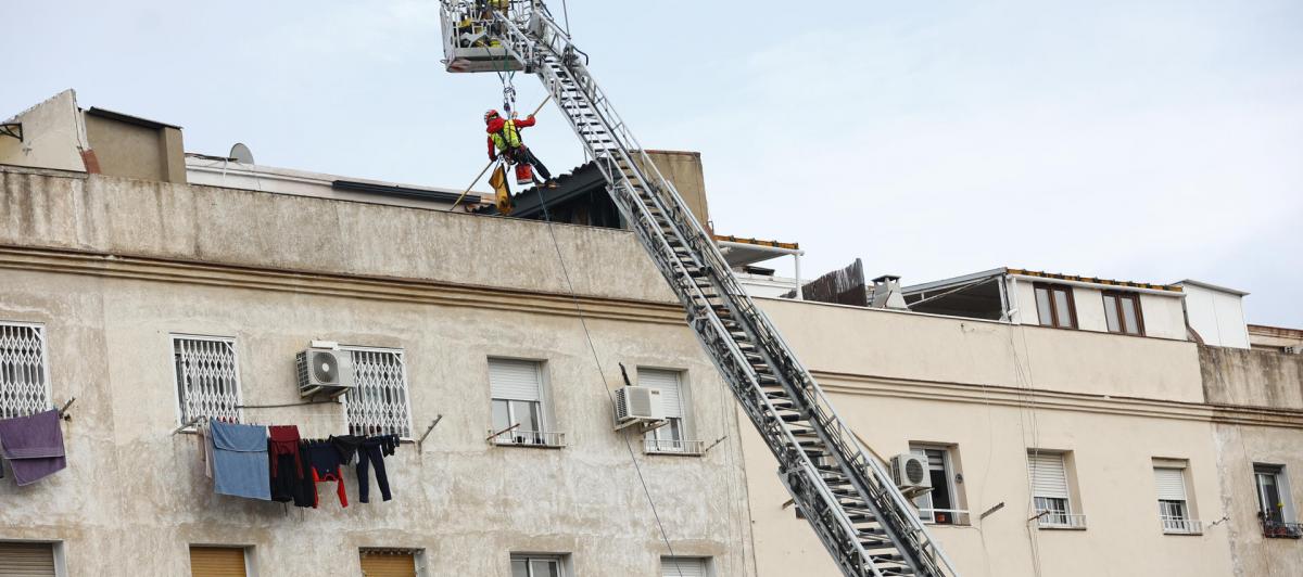Los bomberos inspeccionan el interior de un edificio de cinco pisos, el bajo y otros cuatro, que se ha derrumbado en la calle Canigó de Badalona (Barcelona), al haber cedido el forjado de la construcción.
