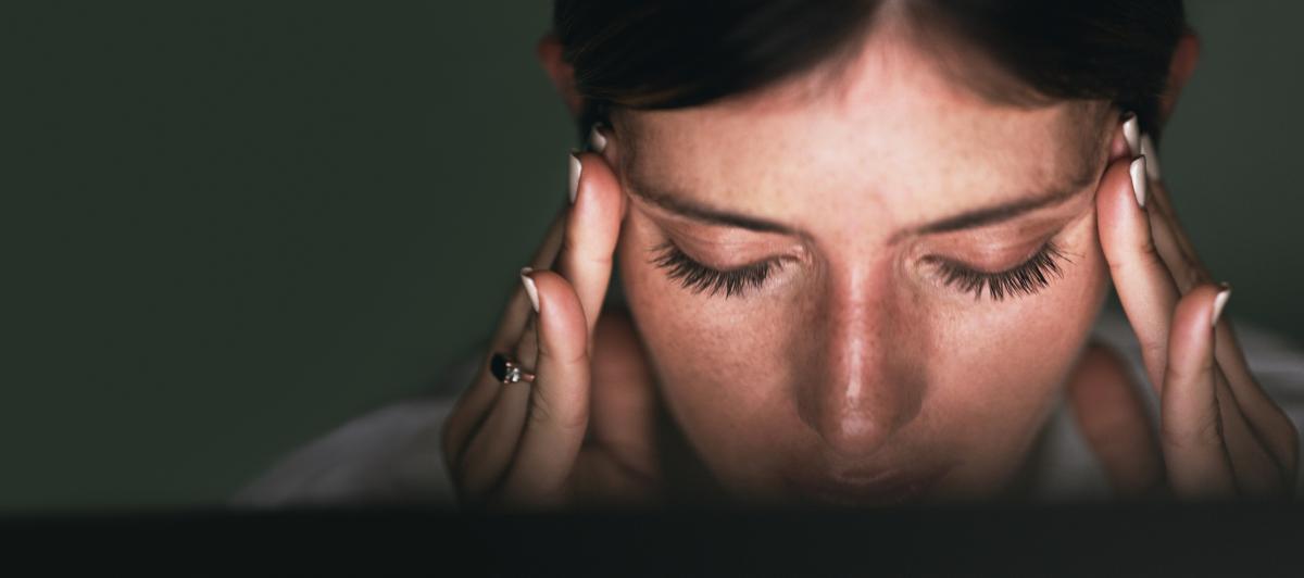 Una mujer sufriendo migraña.