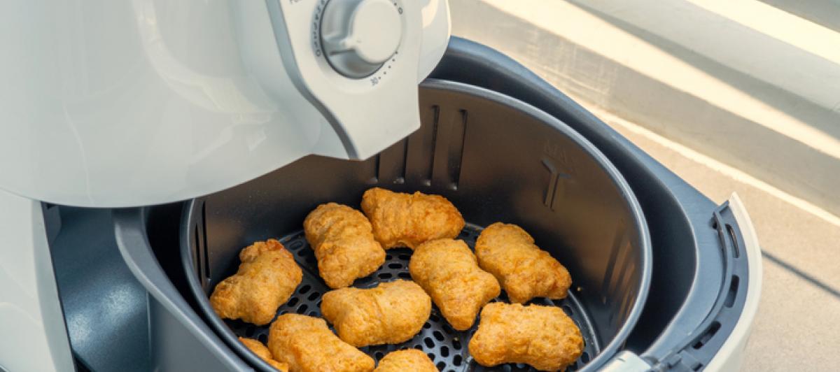 Imagen de archivo de una freidora de aire, con 'nuggets' de pollo.