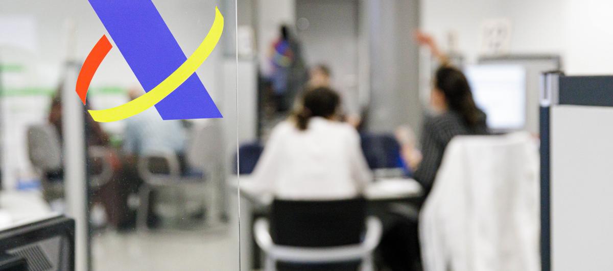 Varias personas en una oficina de la Agencia Tributaria.