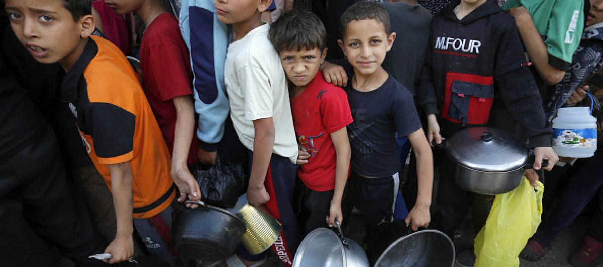 Imagen de archivo de varios niños gazatíes haciendo cola para recibir comida de la escasa ayuda humanitaria que ha logrado llegar a la Franja.
