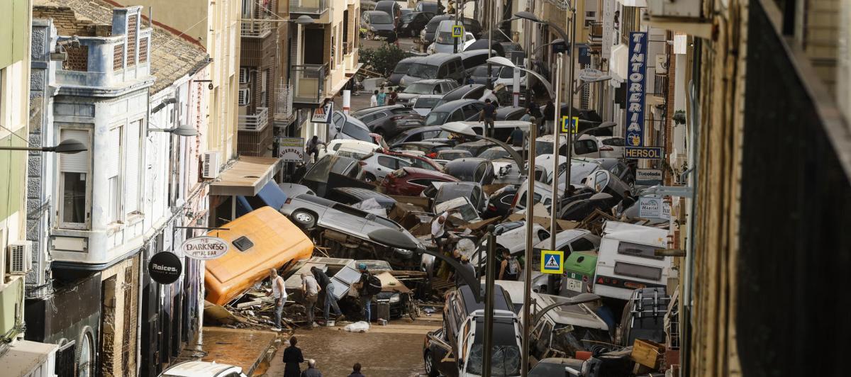 Vehículos amontonados en una calle tras las intensas lluvias de la fuerte DANA en Picaña, Valencia.
