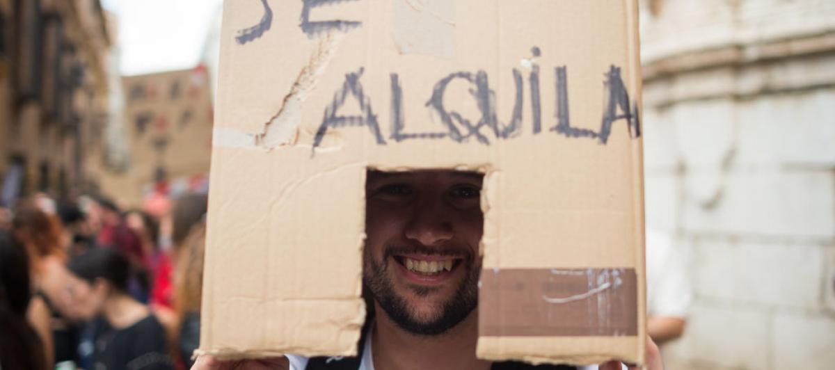 Un manifestante lleva una caja que representa una casa en alquiler en una manifestación en Málaga exigiendo una vivienda digna.
