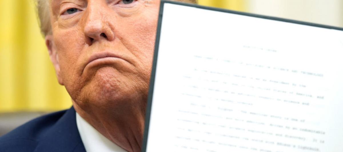 Donald Trump posa orgulloso con uno de sus decretos
