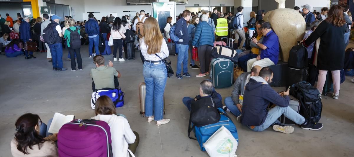 Usuarios aguardan en la estación de tren de Chamartín, en Madrid, tras registrarse un apagón a nivel peninsular este lunes.
