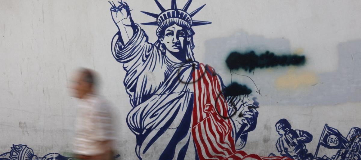 Un hombre pasa delante de un mural contra Estados Unidos en Teherán.