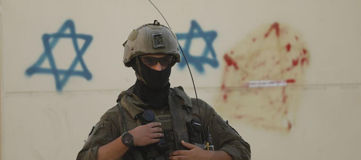 Un soldado de Israel, ante unas pintadas con estrellas de David, en el centro ocupado de Hebrón, en Cisjordania.