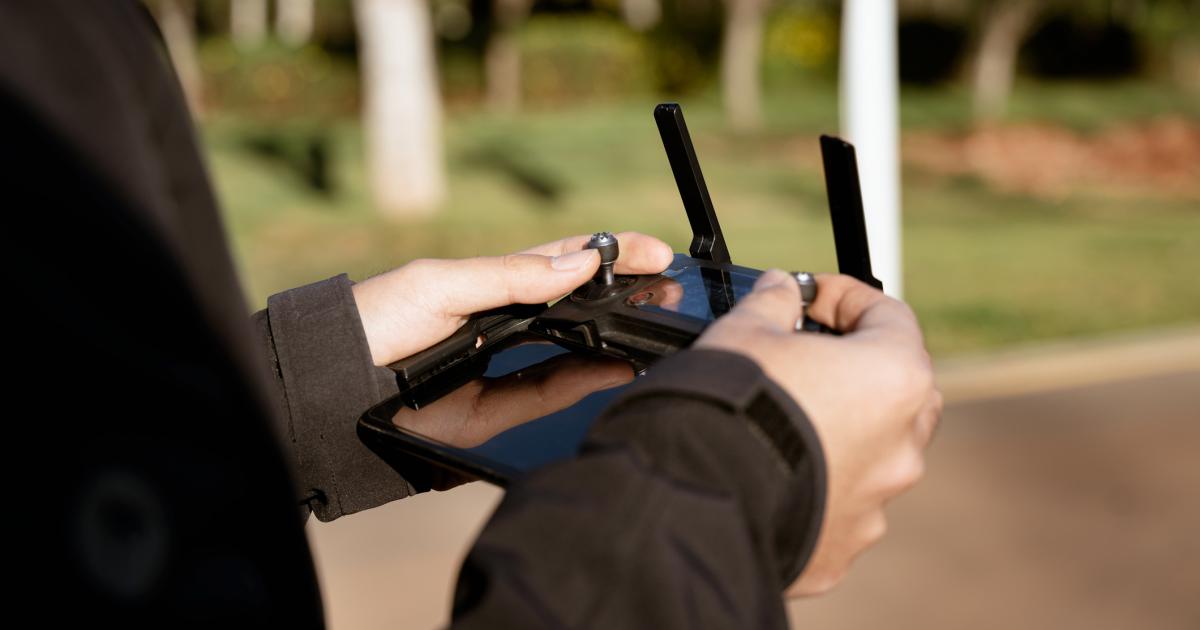 Una persona controlando un dron mediante un joystick.