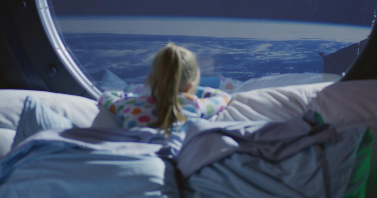 Ilustración de una niña mirando por la ventana de una nave espacial.