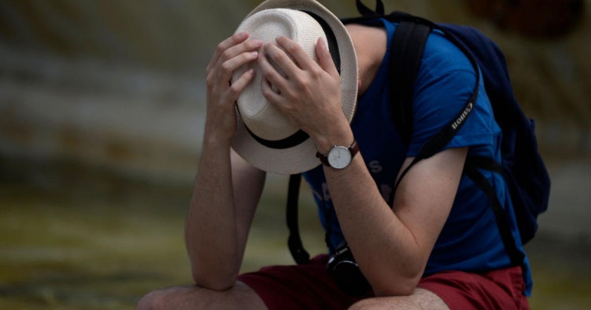 Un hombre se protege como puede en un día de calor fuerte en Sevilla