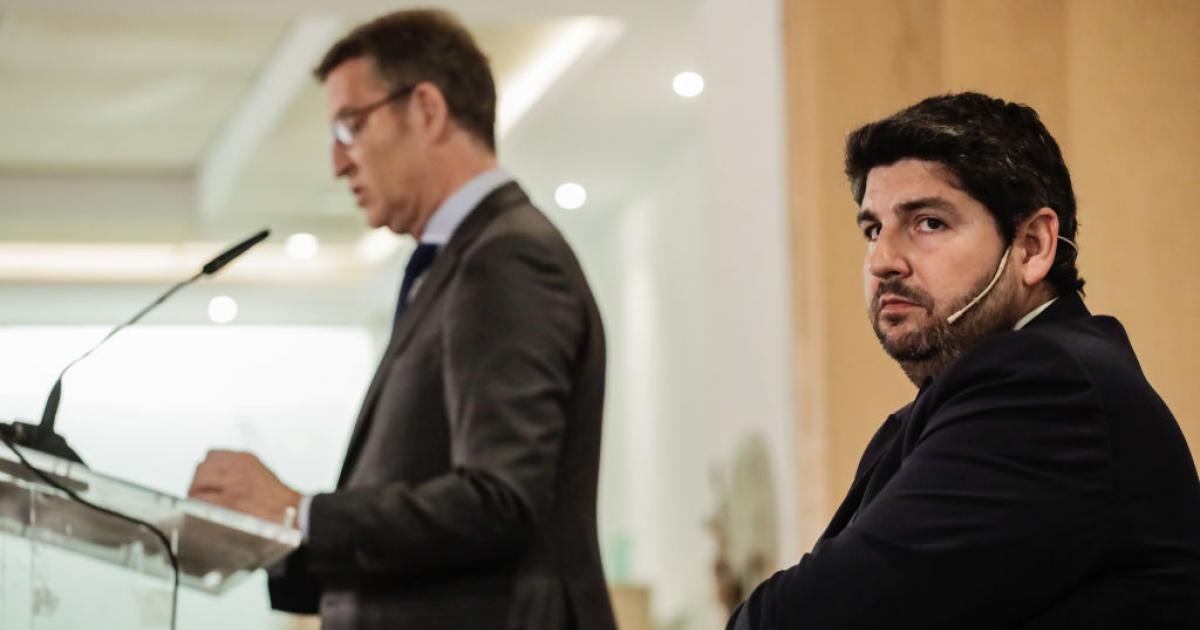 López Miras, mirando durante un discurso de Núñez Feijóo