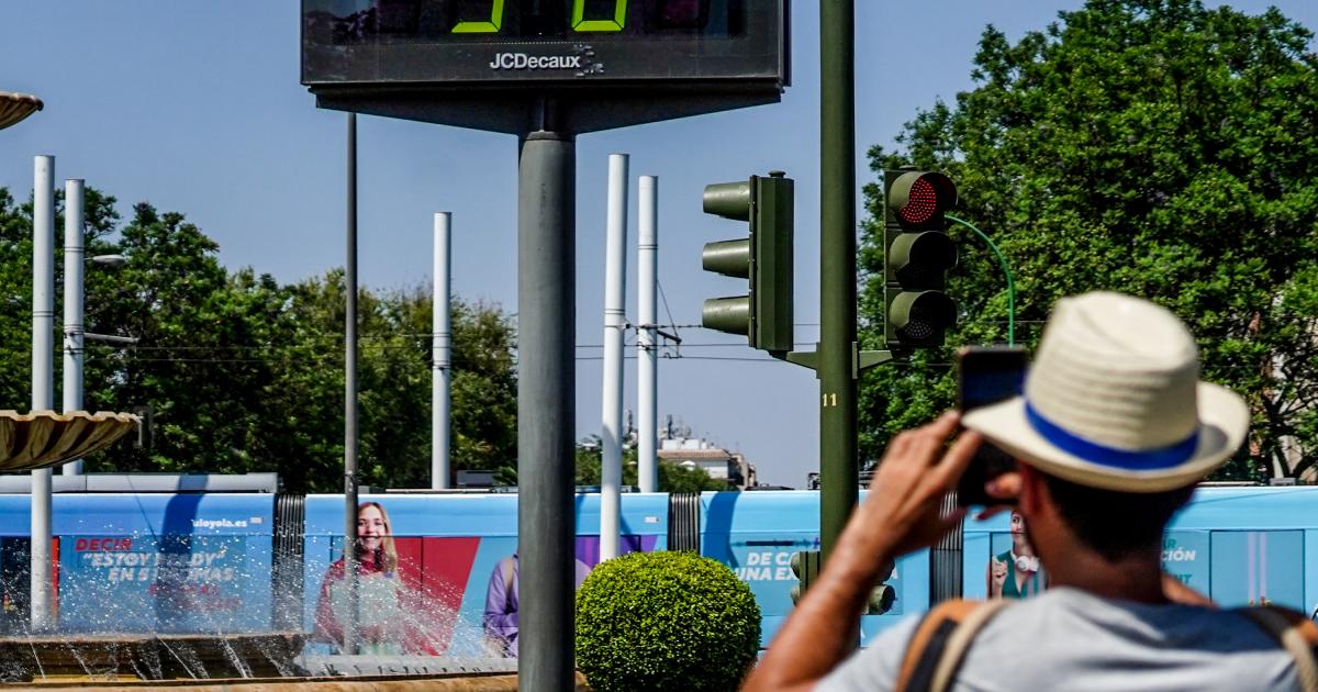 Foto de archivo de una persona haciendo una fotografía a un termómetro de Sevilla.