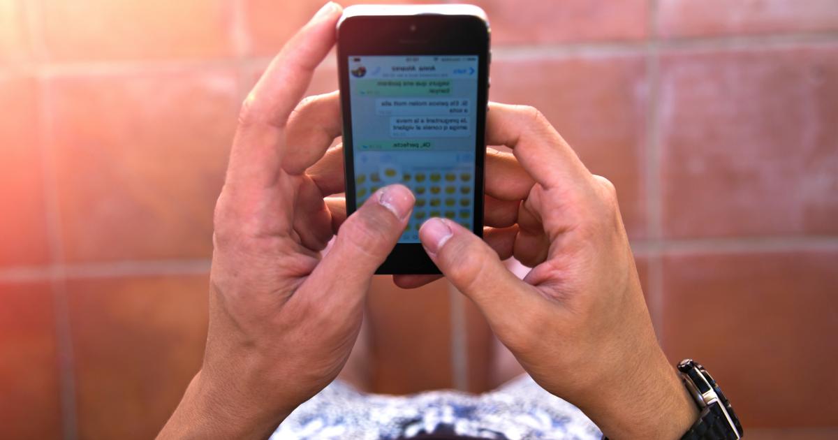 Imagen de archivo de una persona leyendo una conversación de WhatsApp.