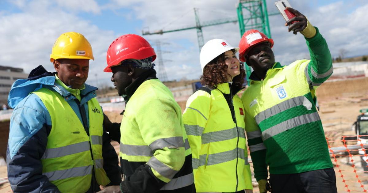 La presidenta de la Comunidad de Madrid, Isabel Díaz Ayuso, sacándose un selfi con un operario en una de las actuaciones enmarcadas en el Plan Vive.
