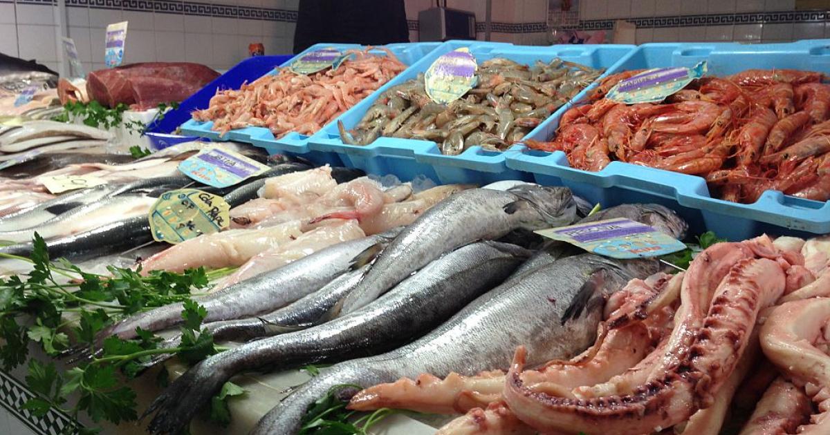 Un pescadero ofrece marisco y pescado.