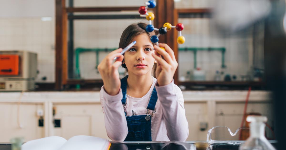 Una niña en clase de química.
