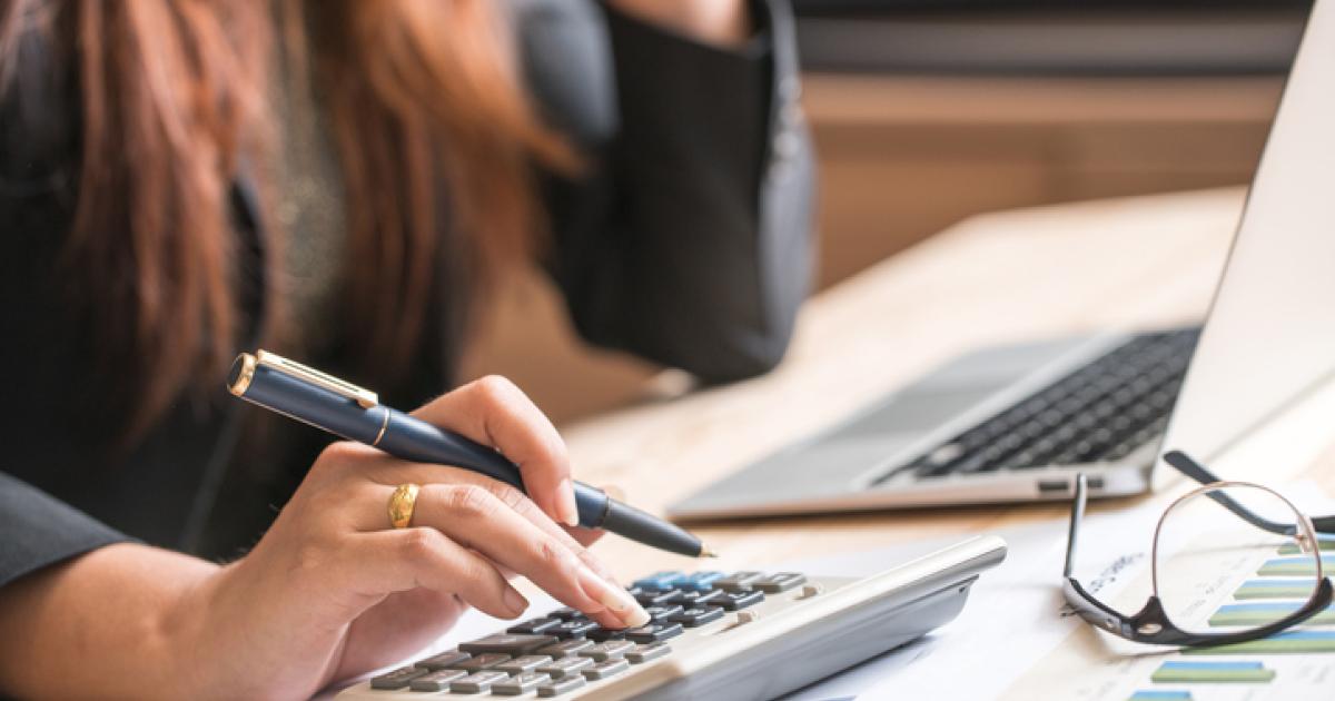 Imagen de archivo de una persona comprobando documentación en su ordenador portatil.