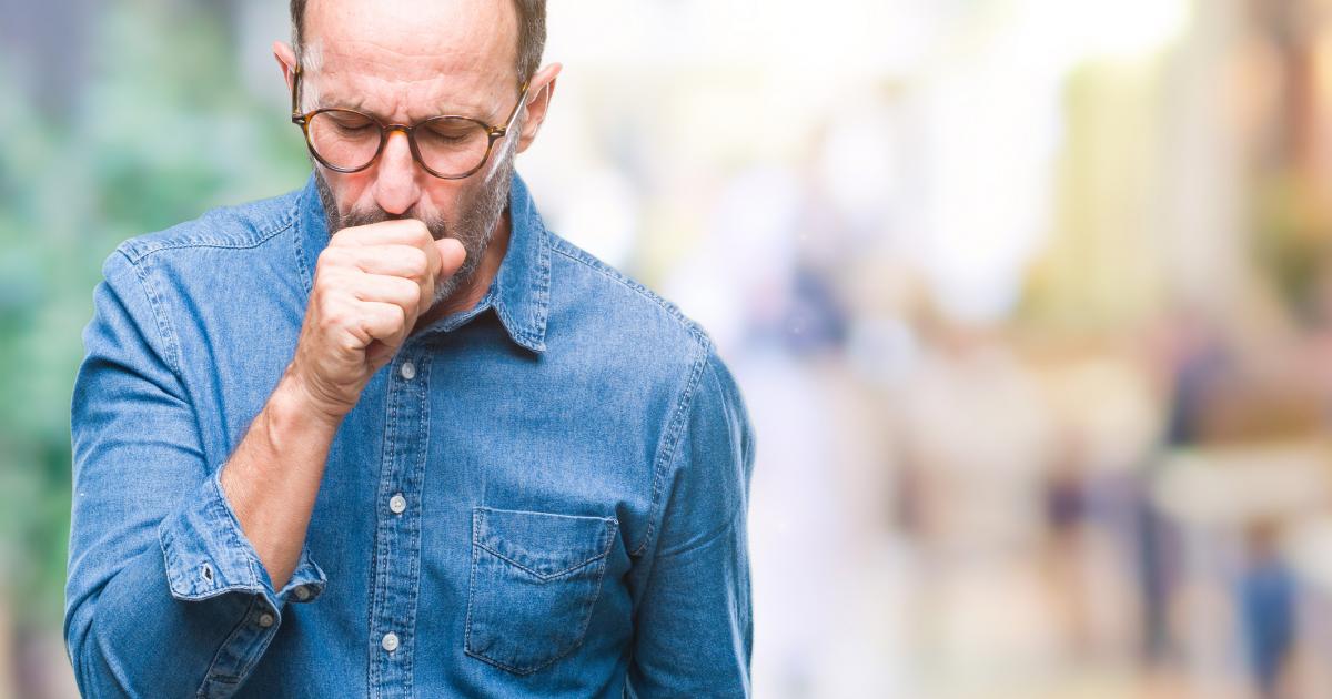 Imagen de archivo de un hombre tosiendo.