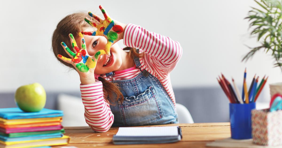 Una niña pintando.