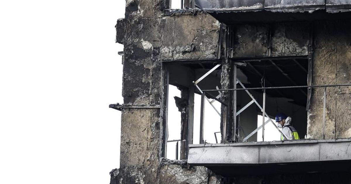 Un agente de la Policía Científica inspecciona una vivienda del edificio incendiado en el barrio de Campanar de Valencia