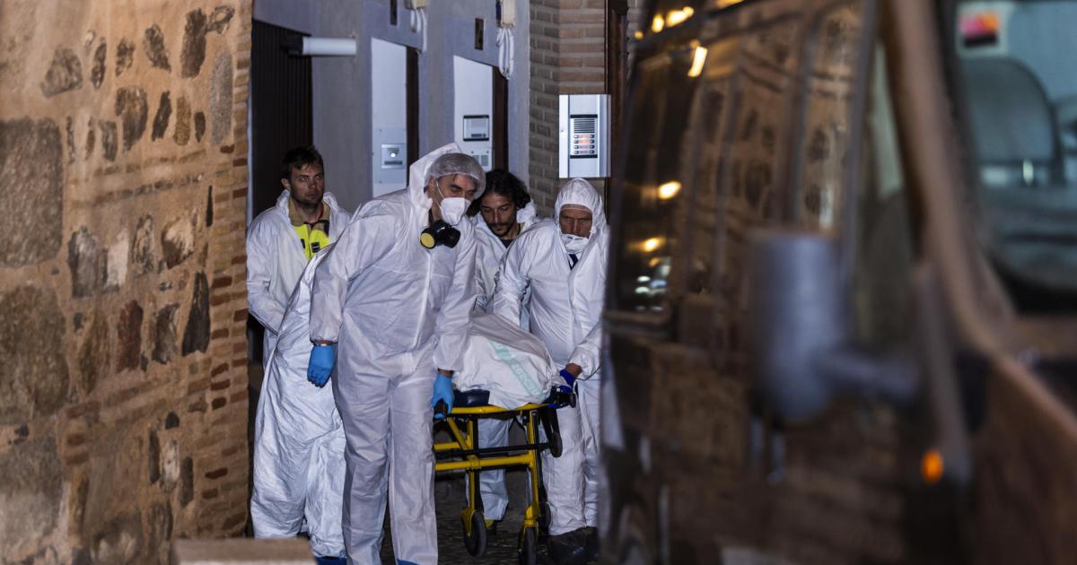 Miembros de los servicios funerarios trasportan uno de los cuatro cadáveres encontrados hoy martes en la calle Santa Leocadia de Toledo, localizados en una vivienda de la capital.