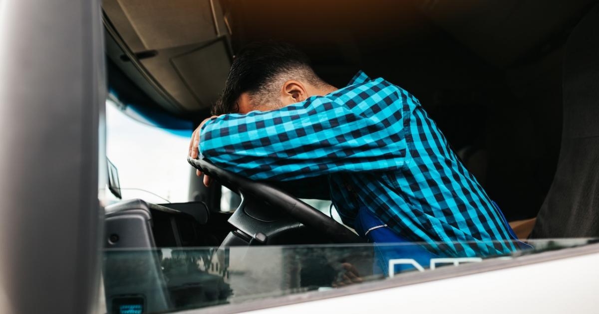 Un conductor, cansado y somnoliento, durmiendo en su camión.