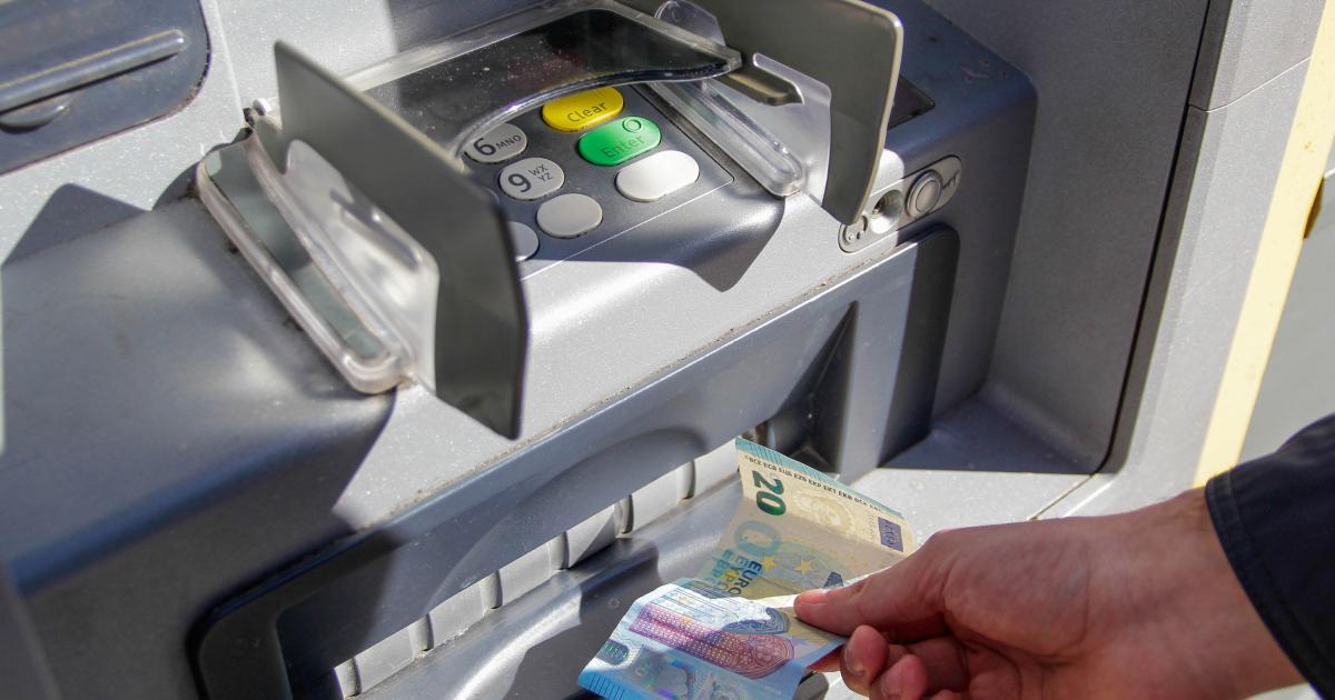 Una persona sacando dinero de un cajero automático.