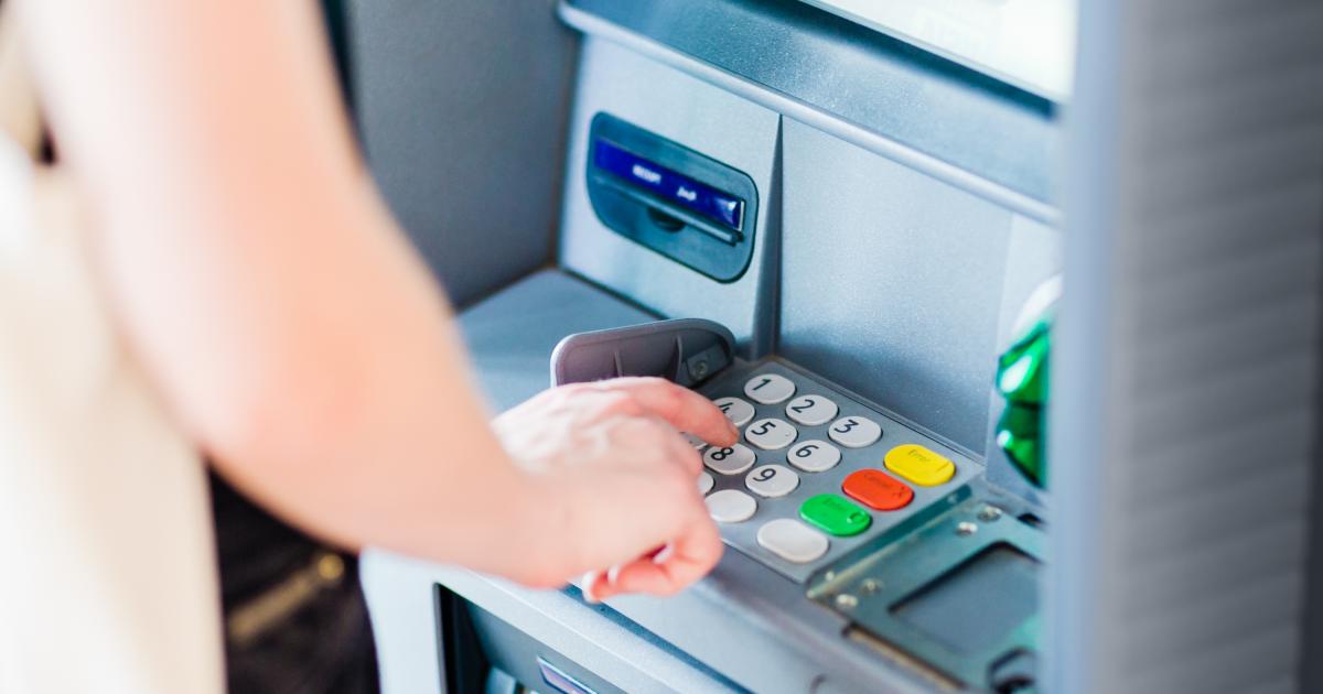 Una persona sacando dinero de un cajero automático.
