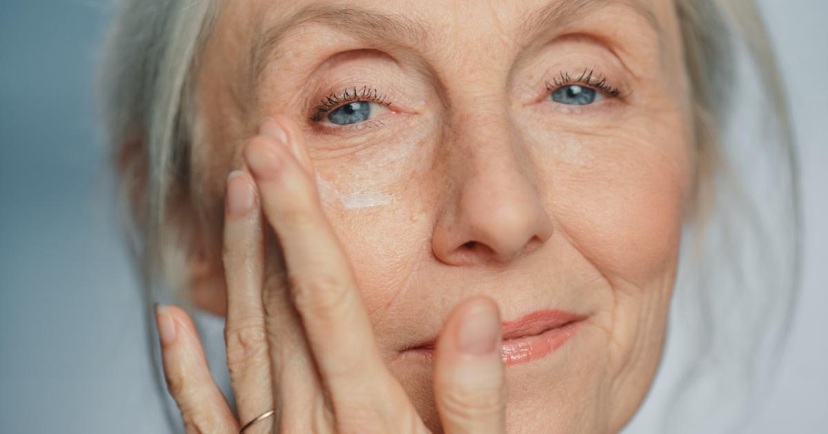 Una mujer aplicándose una crema.