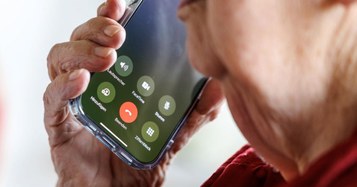 Una mujer de 90 años responde una llamada en su teléfono móvil.