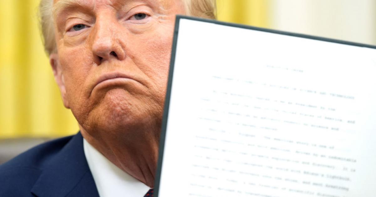 Donald Trump posa orgulloso con uno de sus decretos