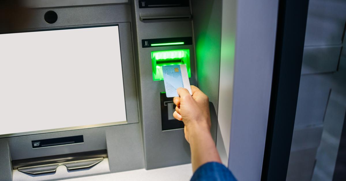 Una persona introduciendo una tarjeta en un cajero automático.